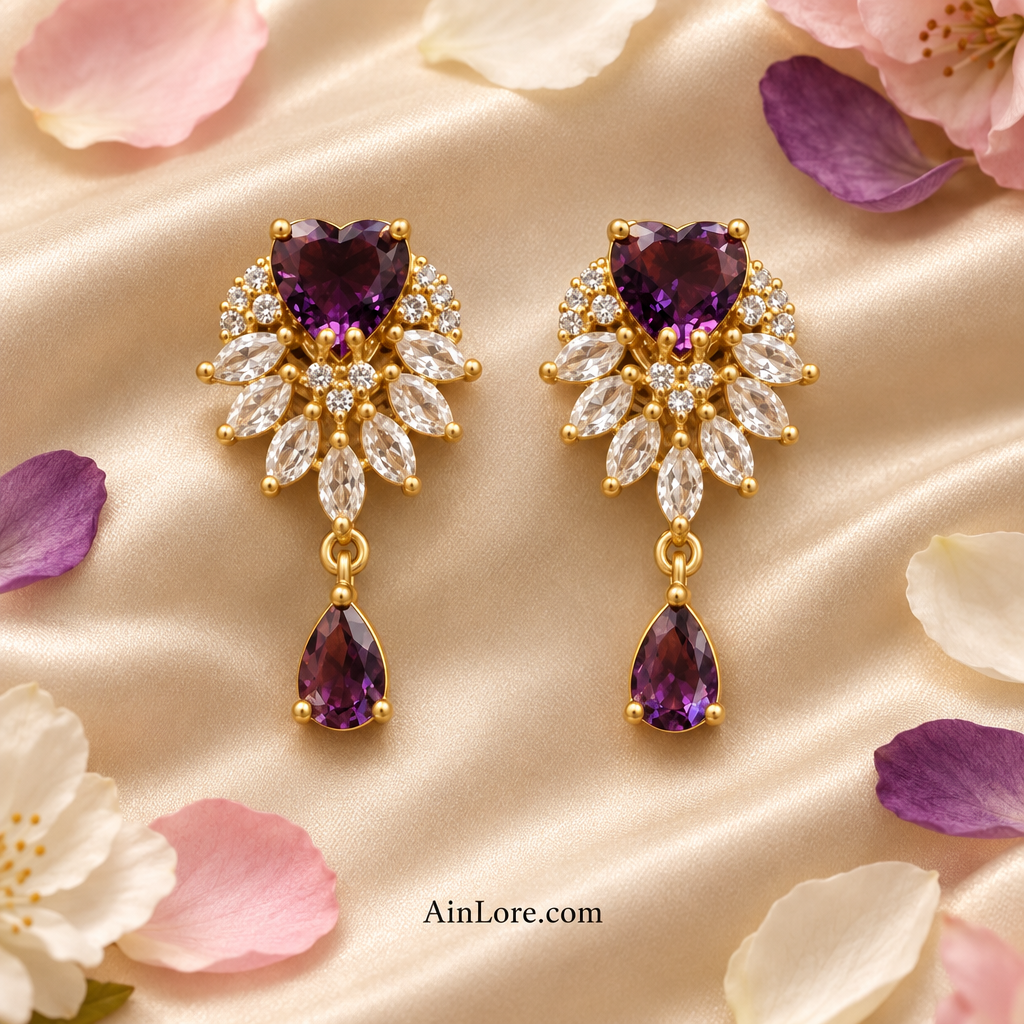Purple heart-drop earrings on dark fabric