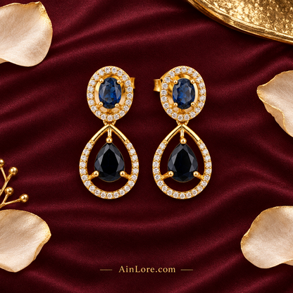 Flatlay of the blue-stone earring pair on burgundy silk