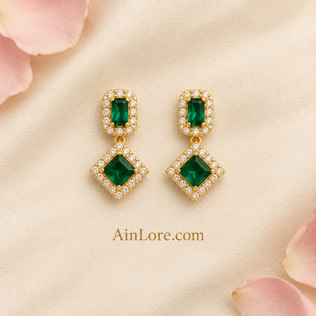 Green geometric earrings on cream fabric