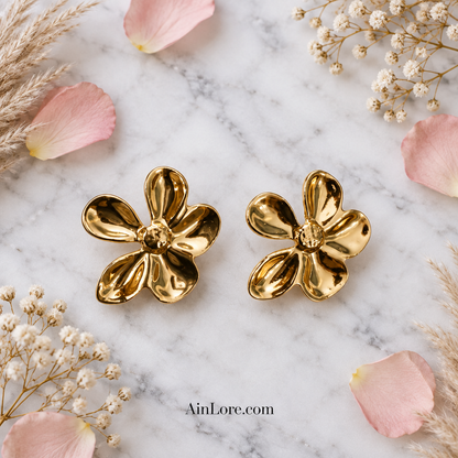 Marble flatlay of the gold flower studs with rose petals and dried flowers