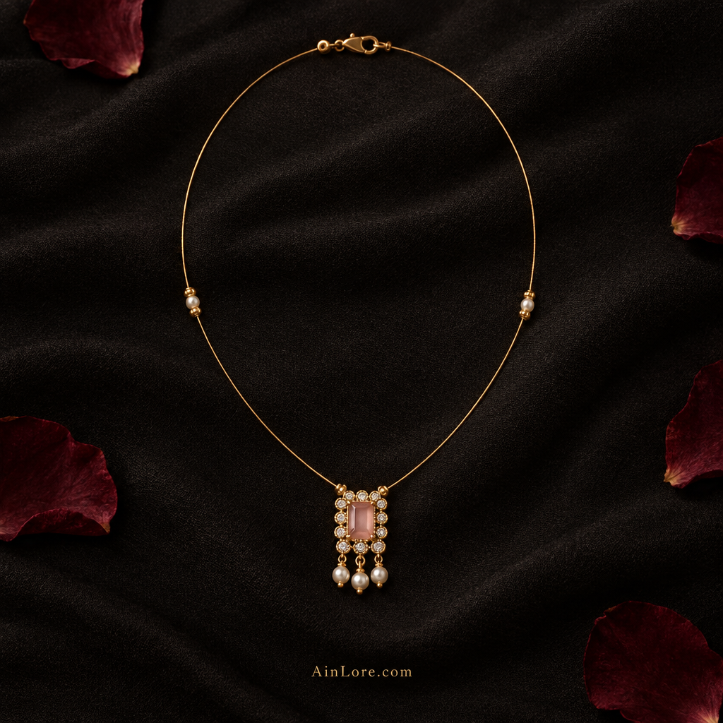 Necklace flatlay on dark fabric with single-layer thin gold-plated wire