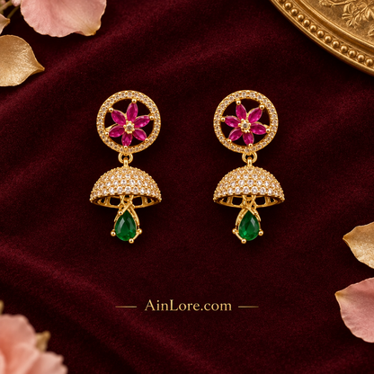Pink-flower and green-drop jhumkas on burgundy velvet