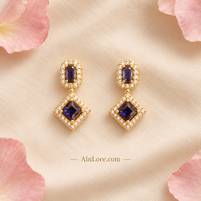 Purple earrings on cream fabric