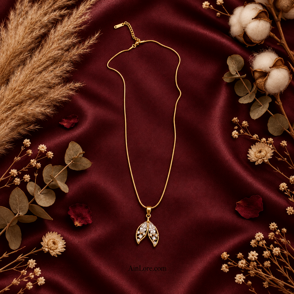 Two-leaf pendant necklace flatlay on satin